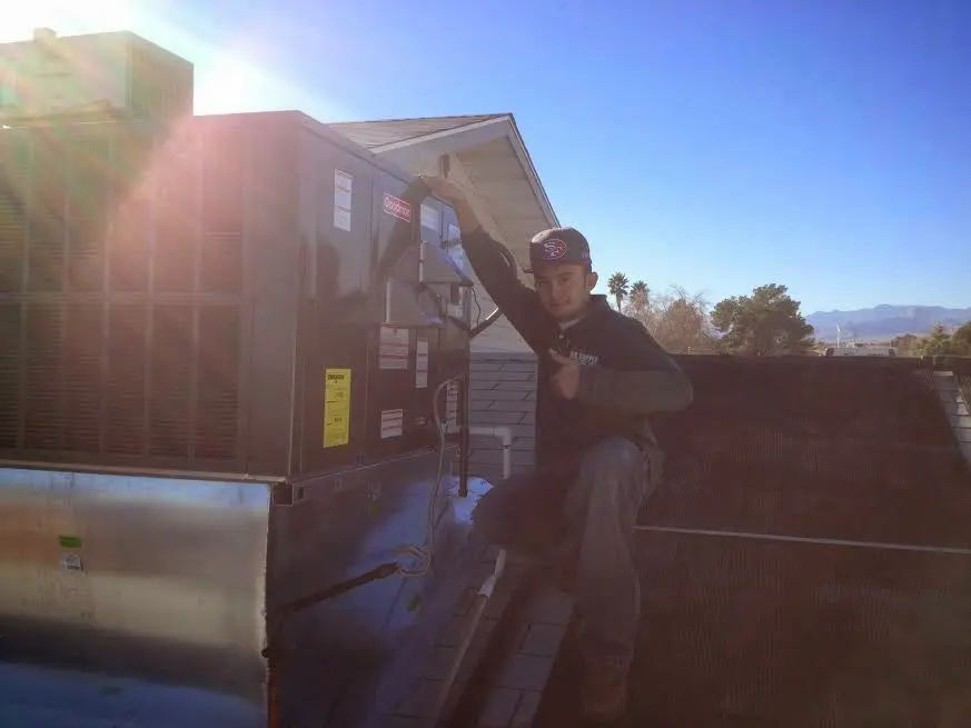 HVAC technician performing HVAC Inspection on a rooftop unit in Lawrenceburg